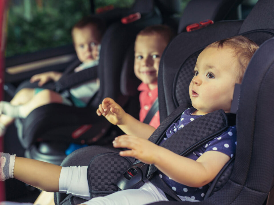 Three children in car safety seat