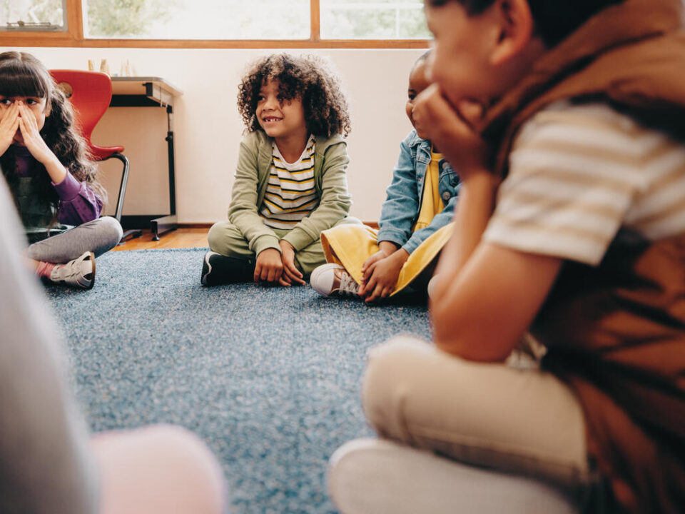 Group of children sitting in a circle in a classroom